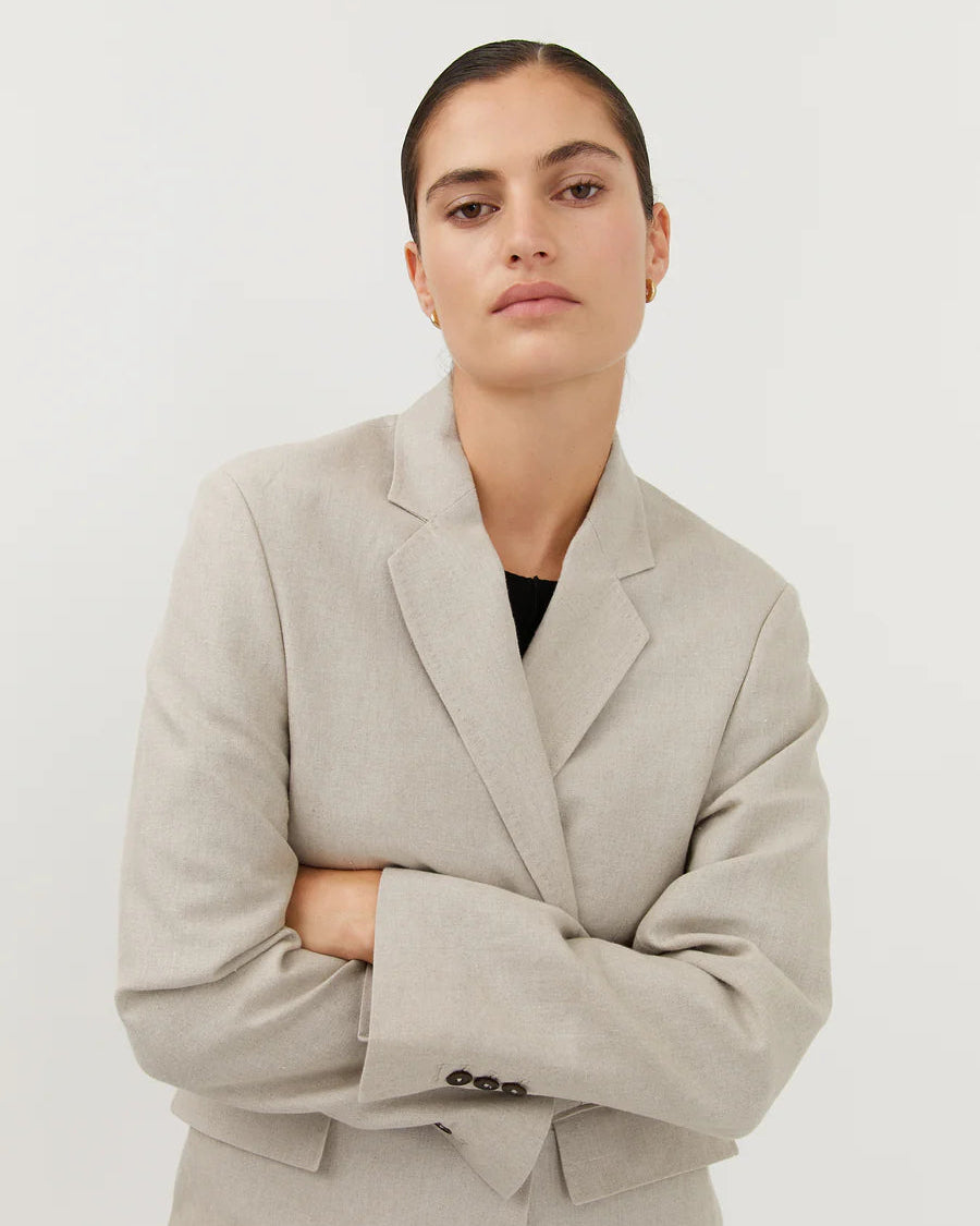 Woman wearing a beige blazer against a white background